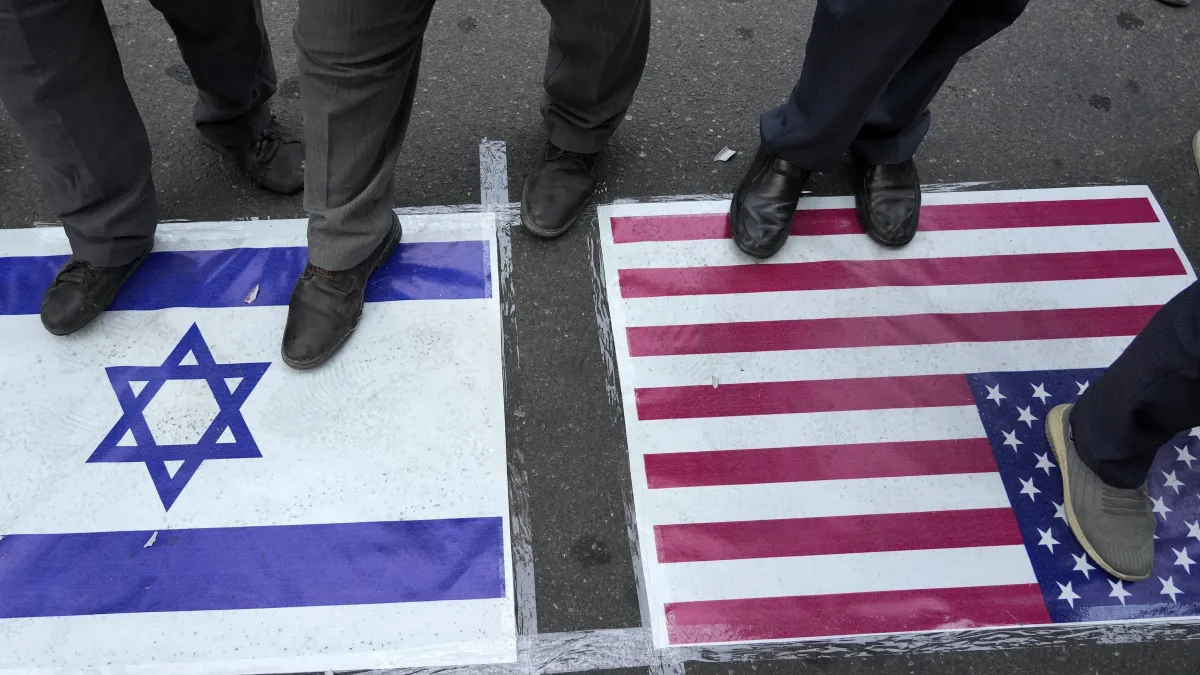 2024年10月8日。在伊朗德黑蘭的巴勒斯坦廣場(Felestin (Palestine) Square)舉行的反以色列集會上,示威者腳踩美國和以色列國旗。(AP)