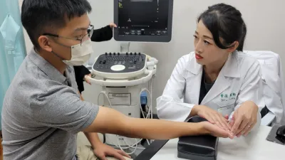 竹科年輕患者有手指麻木現象,李薇醫師說明「腕隧道症候群」原因,並指導保健及治療方式。(圖/方詠騰攝)