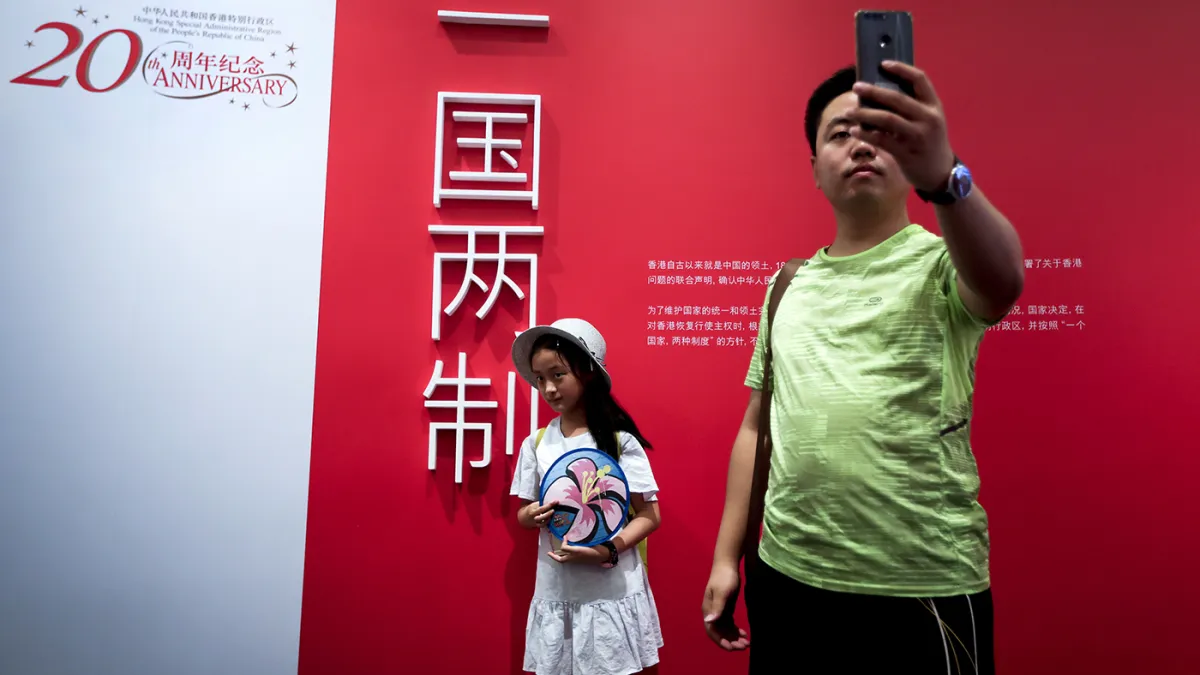 2017年7月2日,民眾在北京的一個慶祝香港回歸、實行一國兩制20週年的活動上留影。(美聯社)