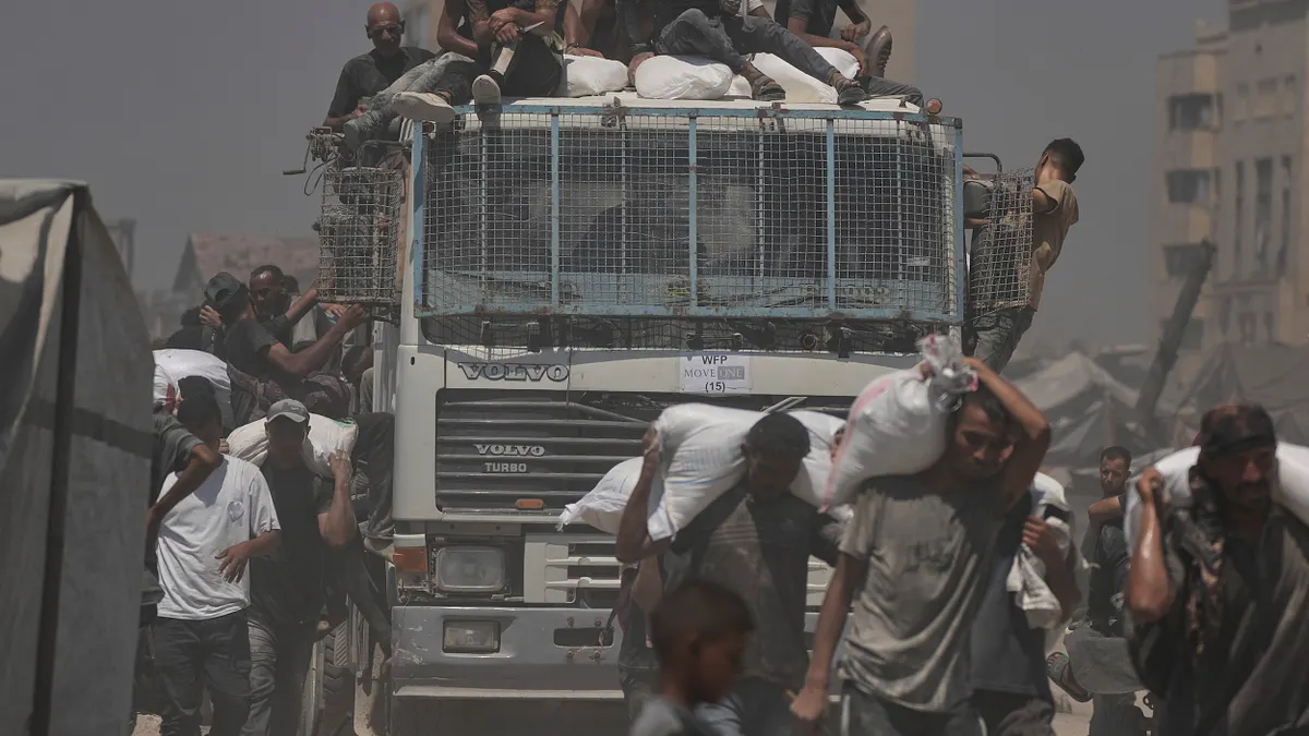 2025年7月27日,人道援助車隊從加薩走廊北部抵達加薩城,巴勒斯坦人正在搬運卸下的麵粉袋。 (資料照,美聯社) 2025年7月27日,人道援助車隊從加薩走廊北部抵達加薩城,巴勒斯坦人正在搬運卸下的麵粉袋。 (資料照,美聯社)