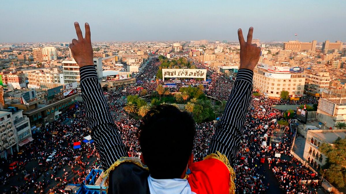 一名伊拉克示威者對著巴格達解放廣場的人群比出勝利手勢。(美聯社) 一名伊拉克示威者對著巴格達解放廣場的人群比出勝利手勢。(美聯社)