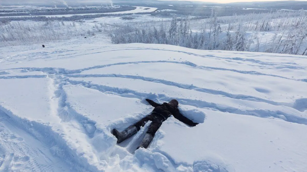 阿亞爾躺在雪地上,等著媽媽和幾個朋友上山來。背景中我們可以看到火力發電廠冒煙的煙囪。(BBC中文網)