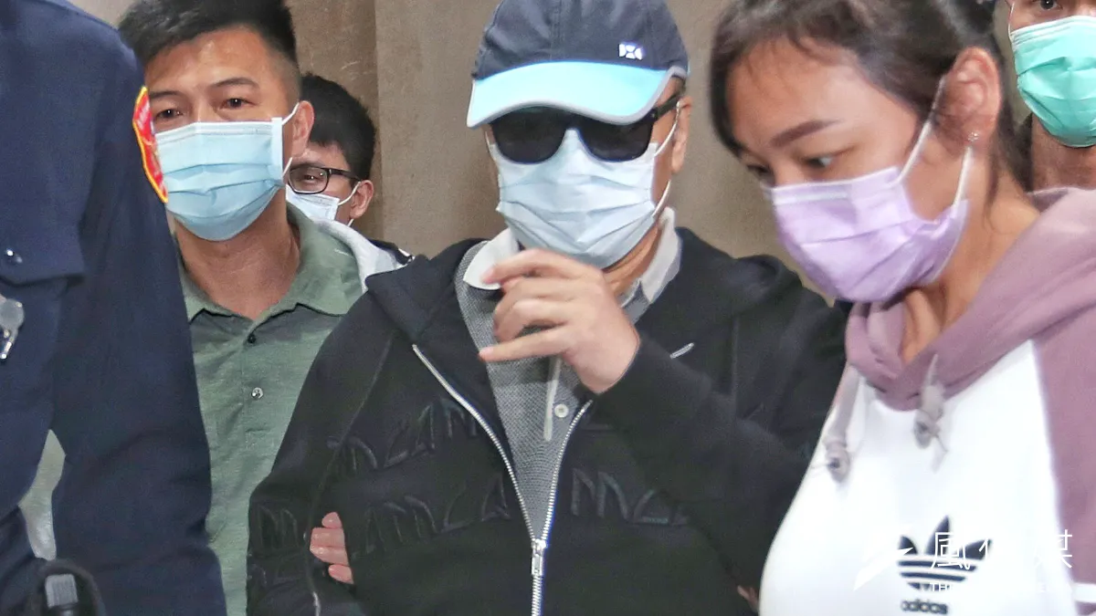 台北地檢署偵訊後,諭令李世聰(中)依《證交法》、公益侵占罪交保200萬元。(林瑞慶攝)