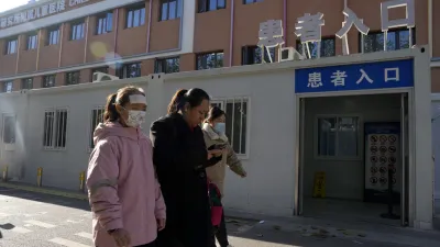 2023年11月24日,北京市民帶著孩子準備到醫院看診。中國官員強調,他們並未發現任何「異常或新型疾病」。(美聯社)