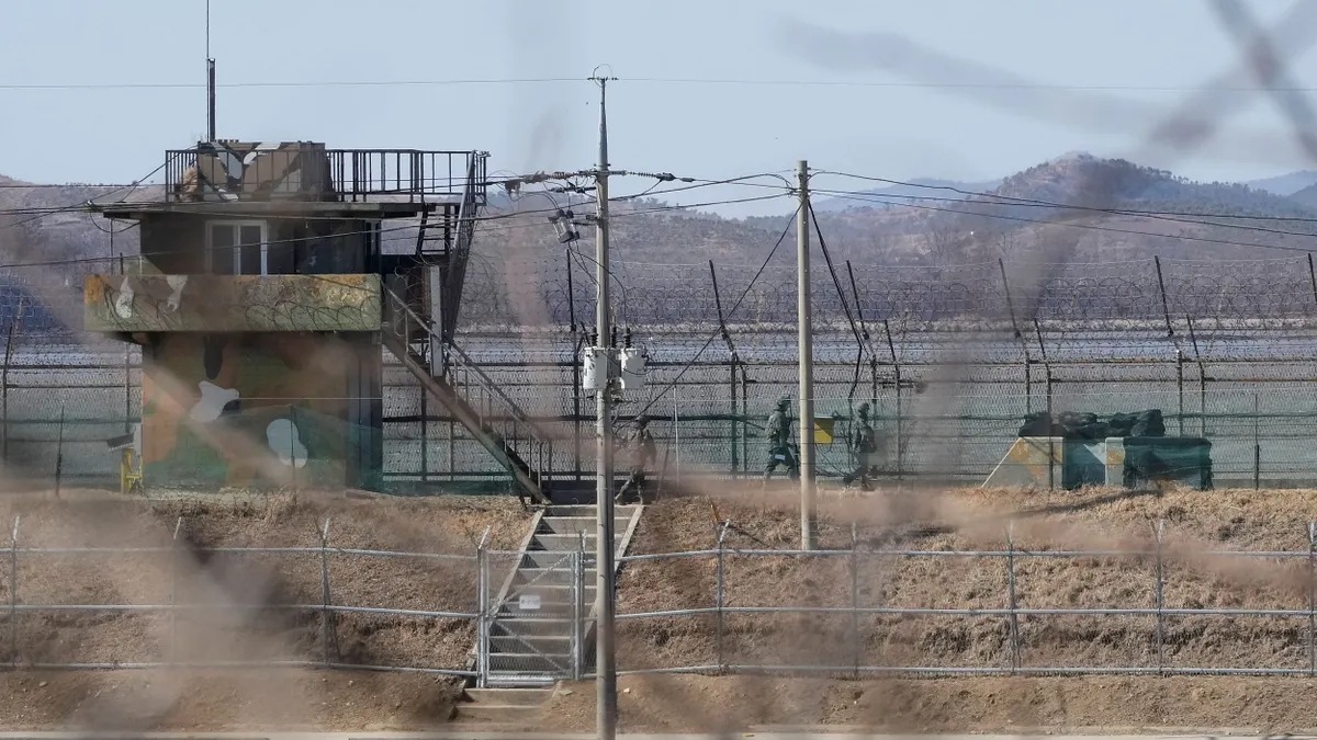 南韓民眾與遊客在DMZ邊境透過望遠鏡遠眺北韓。(美聯社)