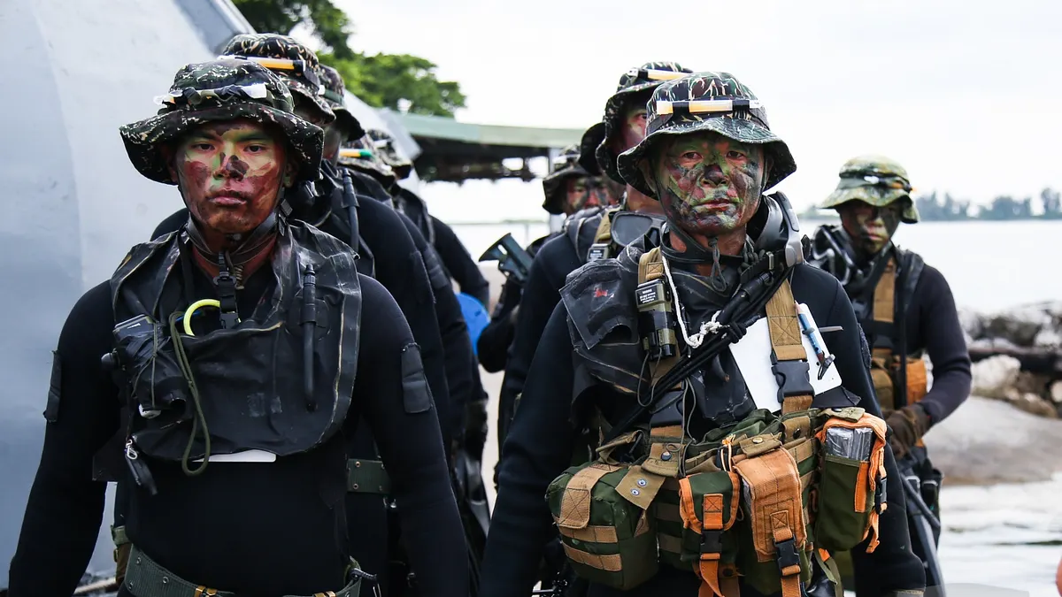 海軍陸戰隊兩棲偵搜大隊「水中爆破專長班」近日進行綜合驗收,已53歲的士官長何朝明(右)也在本次完訓,成為歷年來最年長通過水爆訓的隊員。(取自軍聞社)