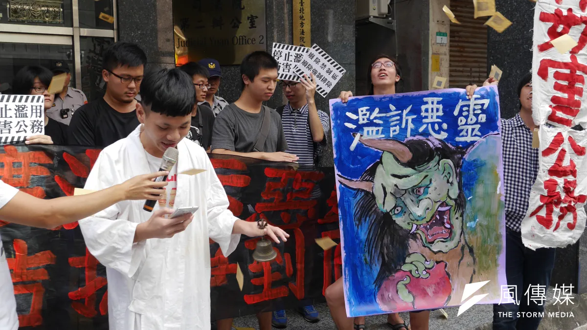 台灣人權促進會等團體,今天上午至台北地檢署執行科發起「超渡濫訴惡靈」行動,由抗爭者扮演法師,誦讀經文並拋灑冥紙。(洪與成攝)