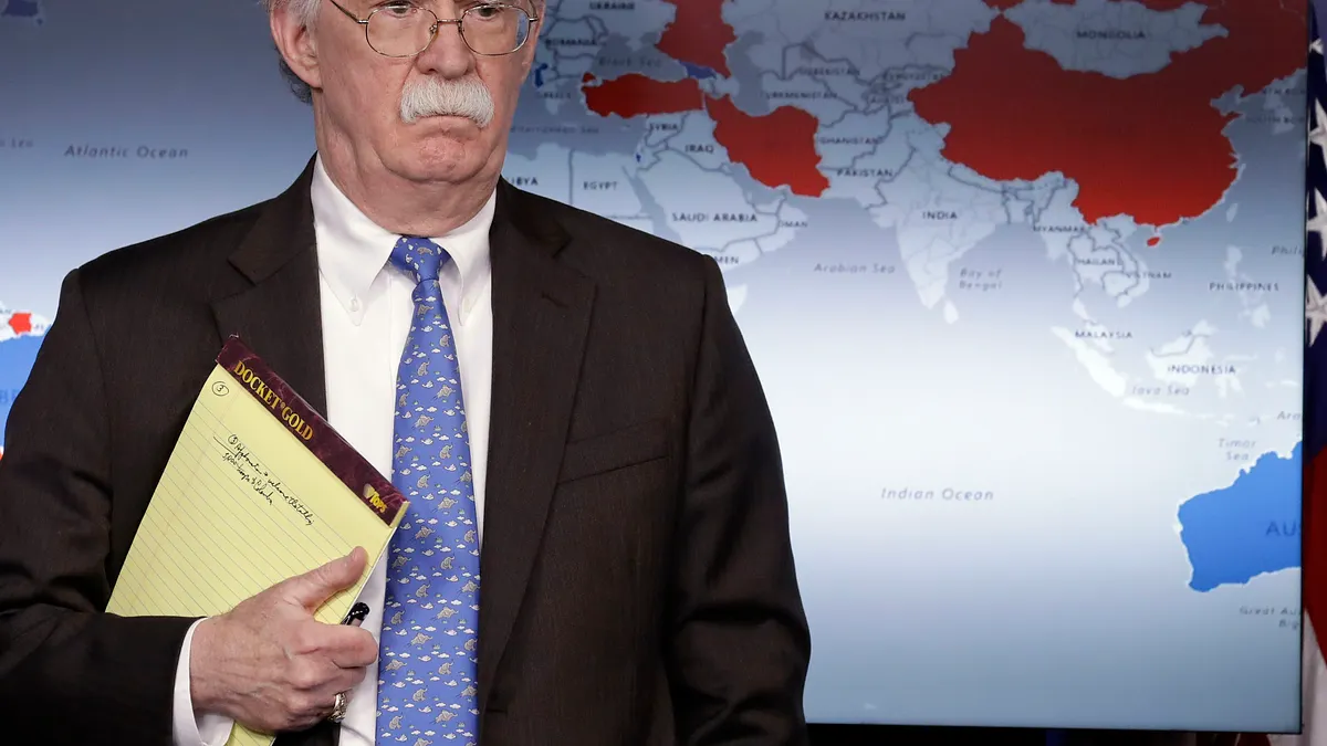 白宮國家安全顧問波頓與財政部長馬努欽在白宮舉行記者會,說明美國對委內瑞拉的經濟制裁。背後的世界地圖中國部分卻透露玄機。(美聯社)