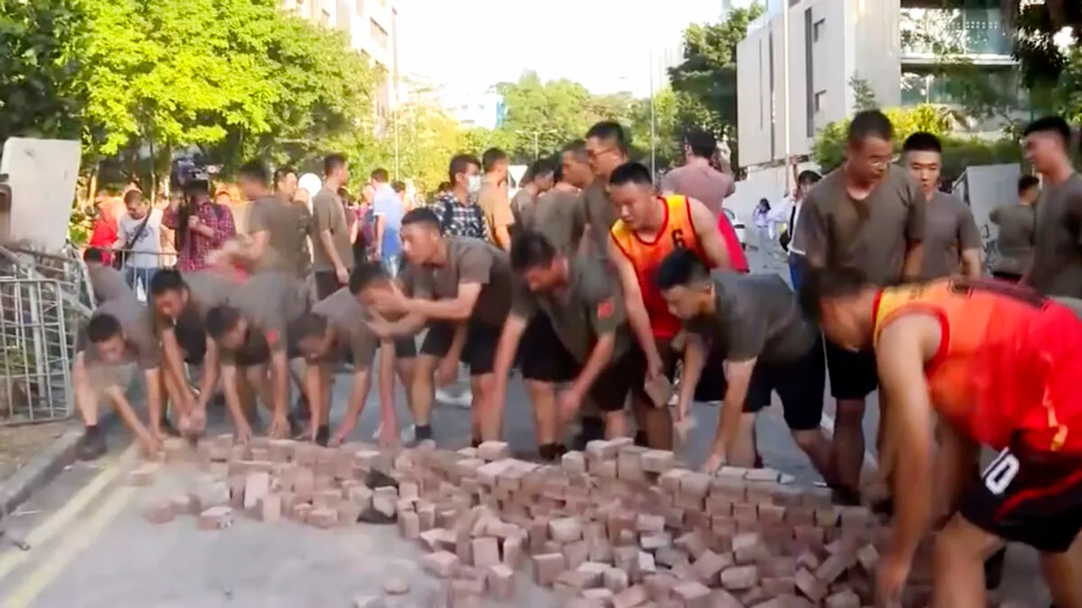 駐港解放軍16日暫離九龍塘軍營,在浸會大學對面的聯福道協助清理路障。(美聯社)