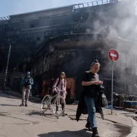 ロシアは24日未明、ウクライナに大規模な空爆を行った。商業施設と隣接する市場は焼け落ち、黒焦げになった外壁だけが残る現場には煙が立ち込め、近隣住民が通り過ぎていた。(写真/中央社提供) ロシアは24日未明、ウクライナに大規模な空爆を行った。商業施設と隣接する市場は焼け落ち、黒焦げになった外壁だけが残る現場には煙が立ち込め、近隣住民が通り過ぎていた。(写真/中央社提供)