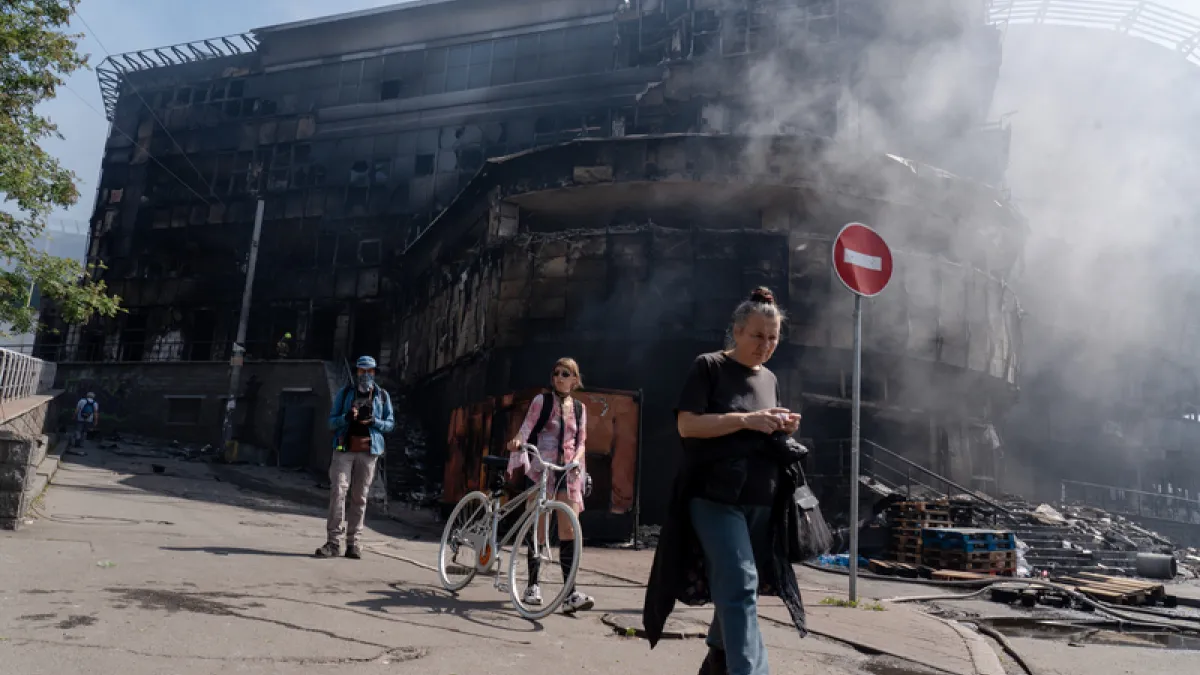 ロシアは24日未明、ウクライナに大規模な空爆を行った。商業施設と隣接する市場は焼け落ち、黒焦げになった外壁だけが残る現場には煙が立ち込め、近隣住民が通り過ぎていた。(写真/中央社提供)