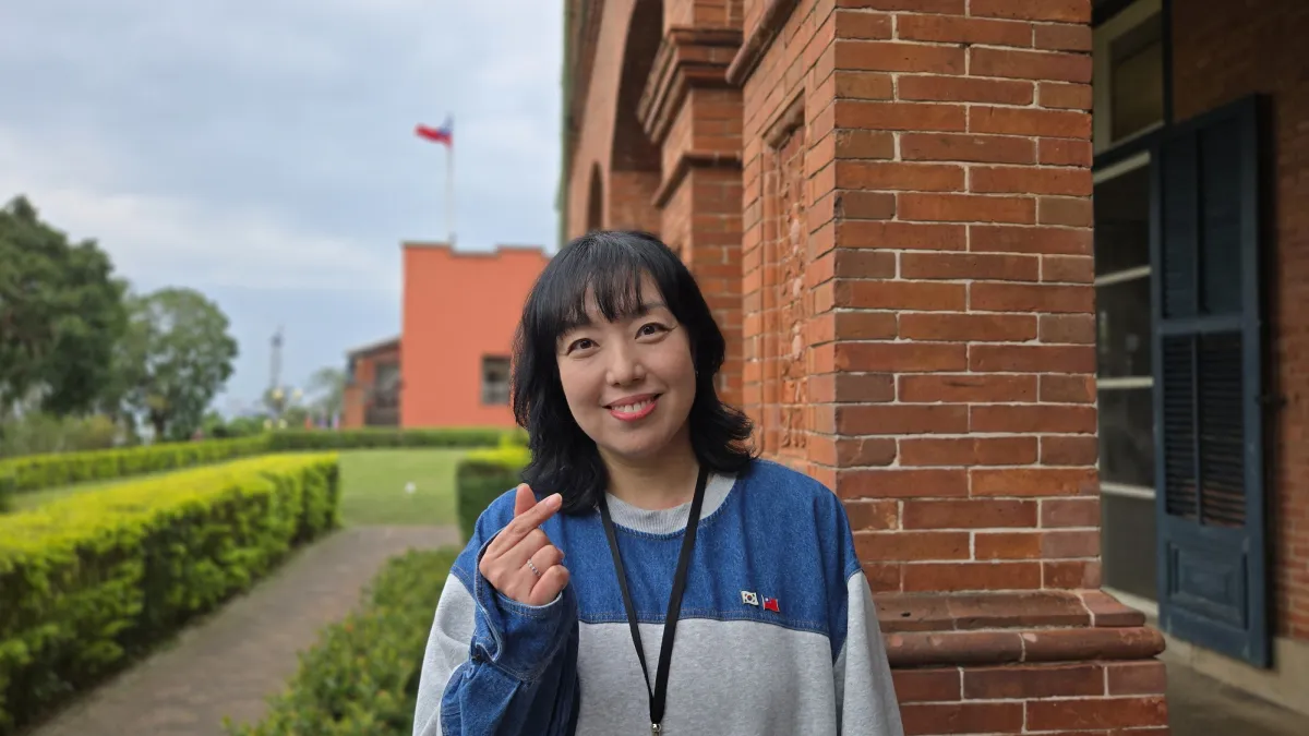 新北市立淡水古蹟博物館首位韓籍志工鄭芝贇,值勤服務時會在胸前掛兩國國旗,方便遊客辨識,歡迎來訪淡水紅毛城時,來與她交流、互動。(圖/新北市立淡水古蹟博物館)