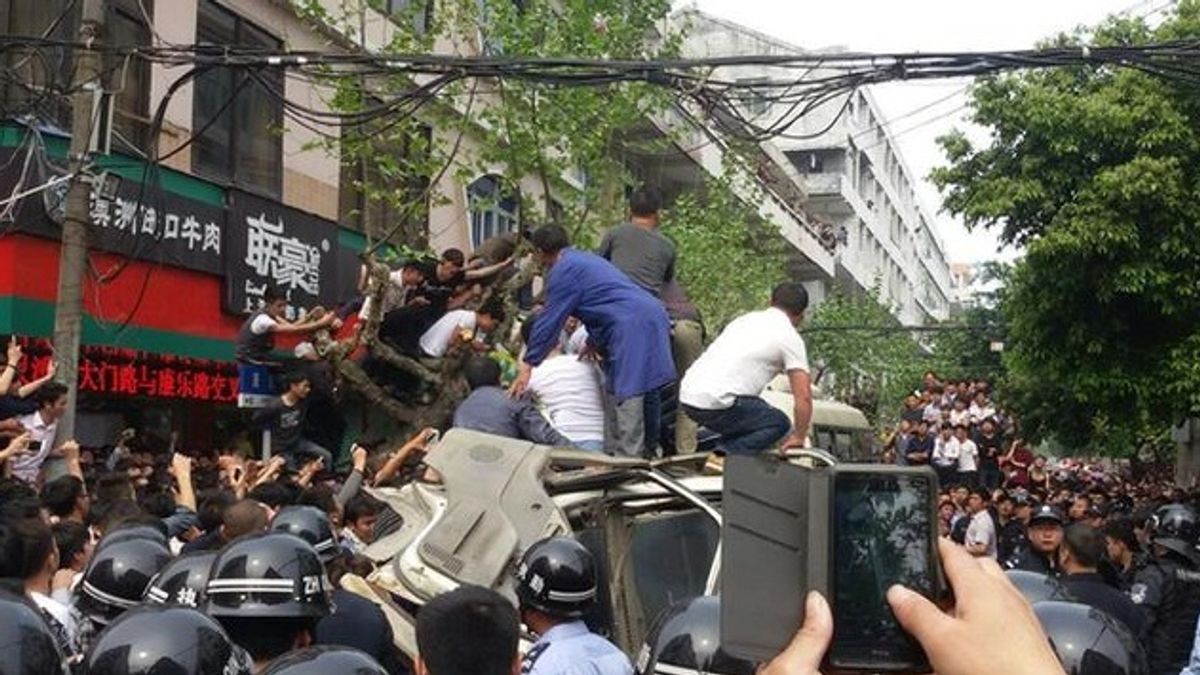 民眾將打人城管的麵包車團團包圍,警方第一時間也無法勸離。(取自網路) 民眾將打人城管的麵包車團團包圍,警方第一時間也無法勸離。(取自網路)