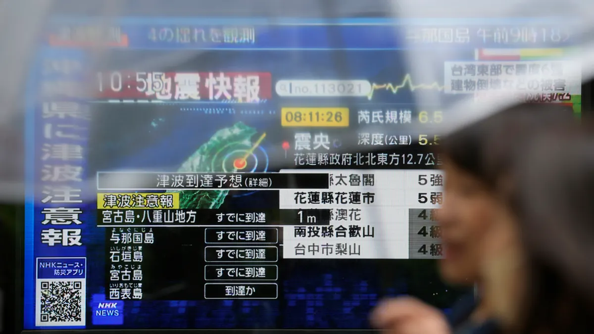 2024年4月3日、東京の街頭テレビで沖縄の津波警報と台湾地震の速報ニュースが放送される。(AP通信)