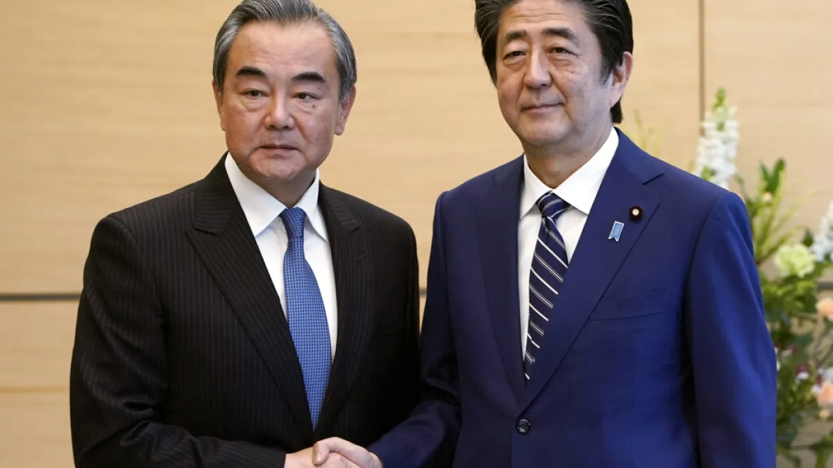王毅(左)言明日本必須「妥善處理台灣問題」,安倍(右)至今未做任何表態。(美聯社)