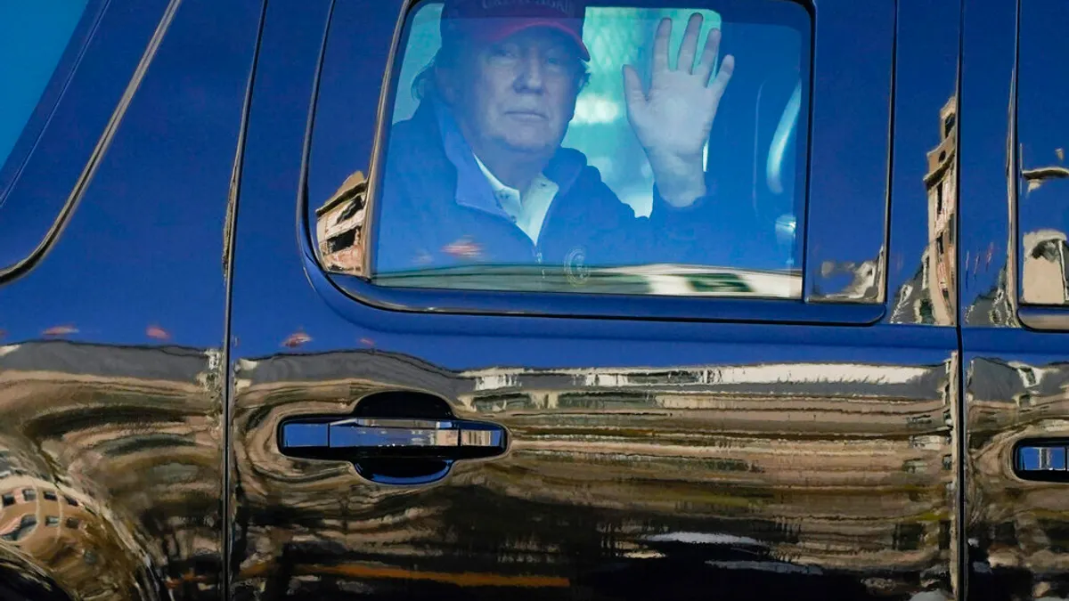 川粉在華府發起挺川大遊行,不願認輸的川普在車上對群眾揮手致意。(美聯社)