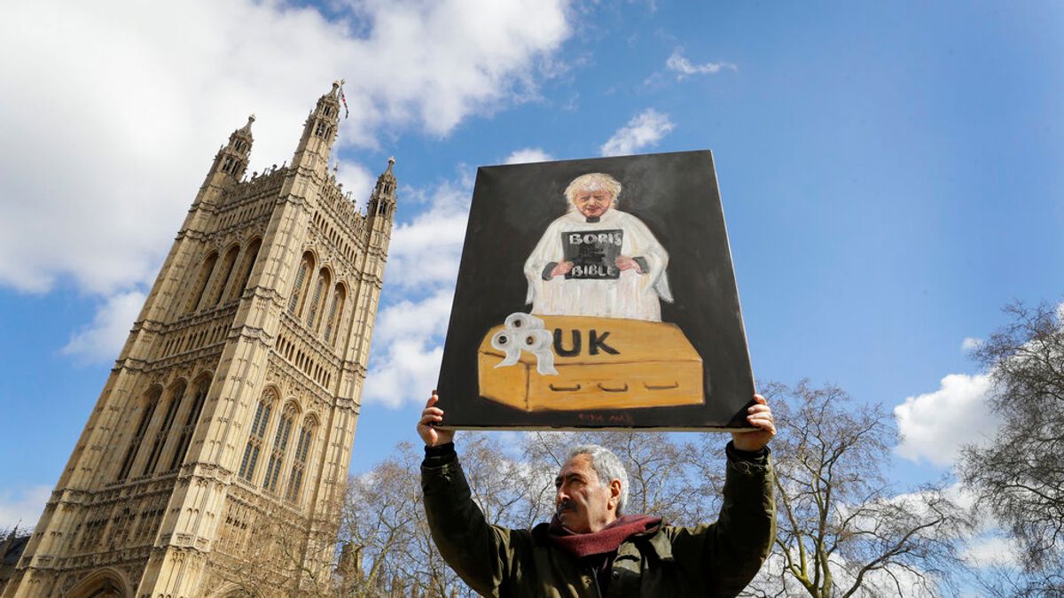 反對強森政策的藝術家馬爾(Kaya Mar)在國會大廈外高舉諷刺漫畫抗議。(美聯社) 反對強森政策的藝術家馬爾(Kaya Mar)在國會大廈外高舉諷刺漫畫抗議。(美聯社)