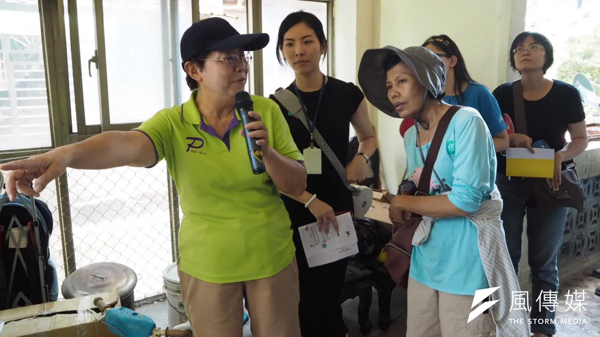 由於北市現兩處公辦都更案未來都將有部分住宅做為公共住宅使用,斯文里長江雪卿(左)帶著20多名報名民眾走入斯文里三期整宅。(尹俞歡攝)