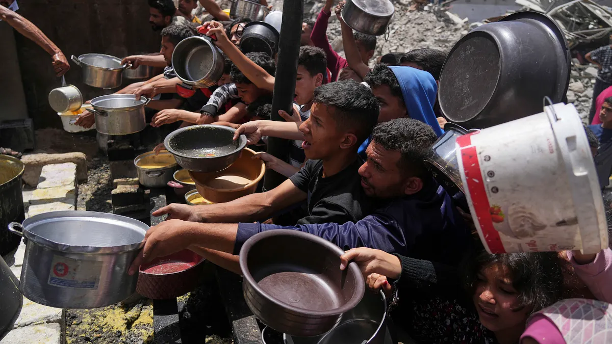 2025年5月19日、ガザ地区北部で食料の配給を受けるパレスチナの避難民たち。食糧不足が深刻化する中、わずかな援助物資に人々が列を作ります。(AP通信) 2025年5月19日、ガザ地区北部で食料の配給を受けるパレスチナの避難民たち。食糧不足が深刻化する中、わずかな援助物資に人々が列を作ります。(AP通信)