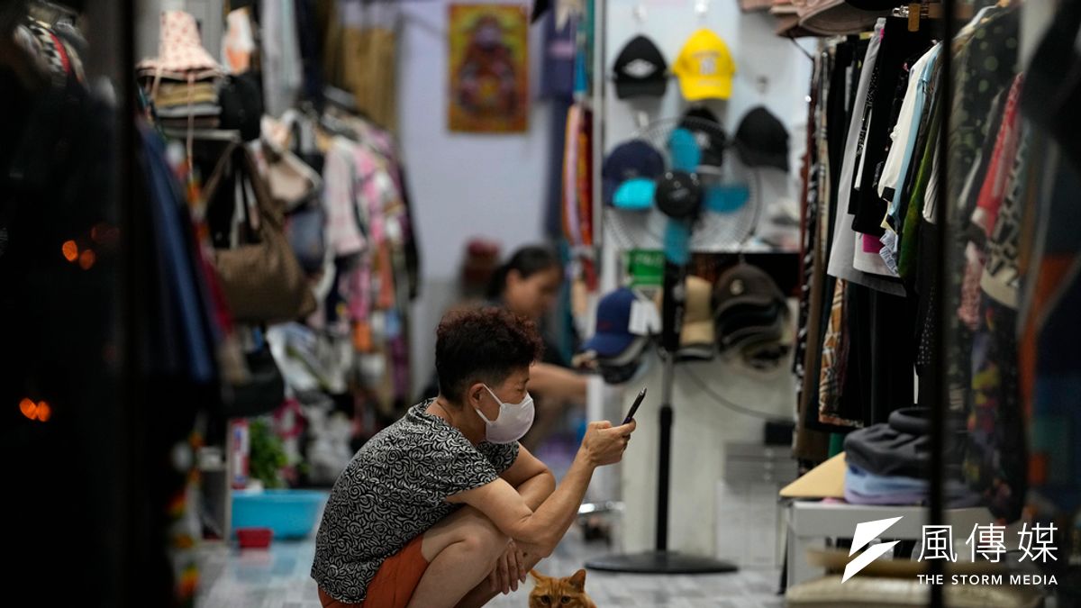 2023年7月27日,北京一家商店的老闆在店貓的陪伴下等待顧客上門。(美聯社) 2023年7月27日,北京一家商店的老闆在店貓的陪伴下等待顧客上門。(美聯社)