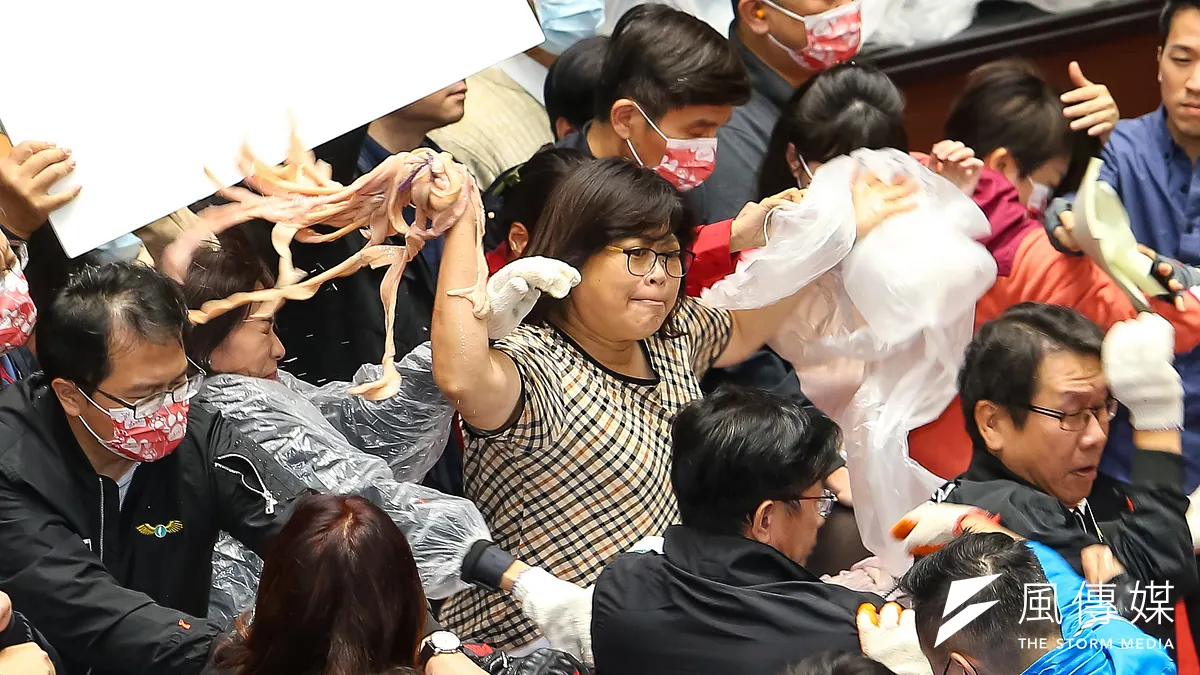 行政院長蘇貞昌27日至立院進行施政報告,遭國民黨委員潑豬內臟杯葛,民進黨立委王美惠(中)將豬腸拋回。(顏麟宇攝)