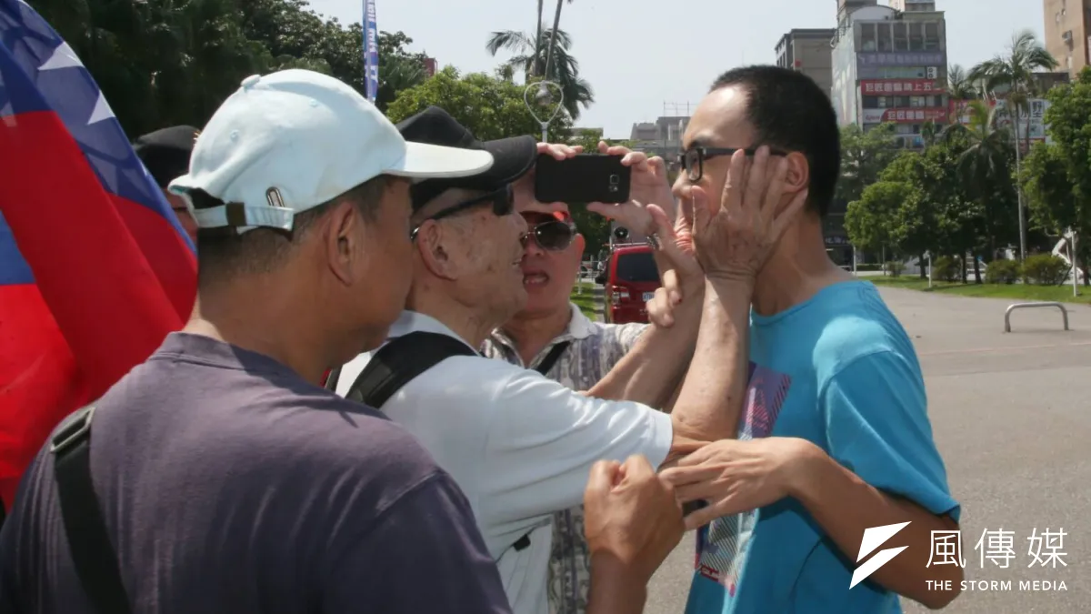 藍天行動聯盟26日在台大校門口抗議「台獨入侵校園」,一名台大學生路過,卻遭藍天盟拍臉頰。(陳明仁攝)