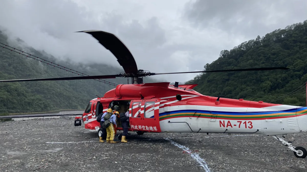 高雄市桃源區因連日大雨,3個部落的重要聯外道路明霸克露橋遭暴漲溪水沖斷,市政府消防局協調內政部空中勤務總隊調派直升機前往發送物資與搶修電力設施。(高雄市政府提供)