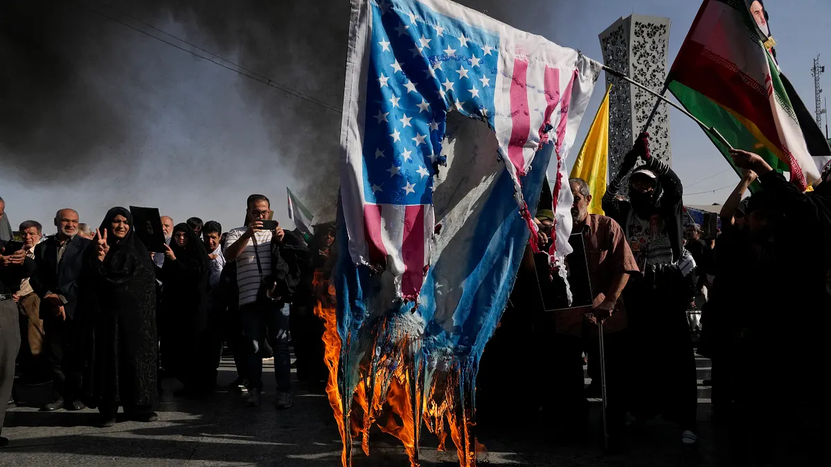 2024年10月2日,德黑蘭的示威者在悼念納斯拉勒的集會焚燒美國和以色列的國旗。(美聯社)