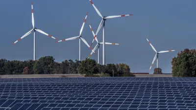 2021年10月28日,風力發電機在德國拉普斯哈根的太陽能發電廠後面轉動。(美聯社)