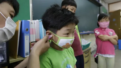 首爾的小學生正在接受體溫檢測。(美聯社)
