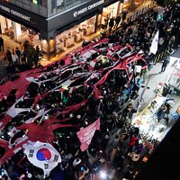 2024年12月9日、ソウルで行われた尹錫悅弾劾デモ。参加者らが与党「国民の力」の党旗を破り捨てる様子。(AP通信) 2024年12月9日、ソウルで行われた尹錫悅弾劾デモ。参加者らが与党「国民の力」の党旗を破り捨てる様子。(AP通信)