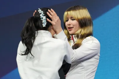 美國華裔花式滑冰選手劉美賢(右)奪下女子個人賽金牌,賽後安慰失誤的日本好手中井亞美。(美聯社)