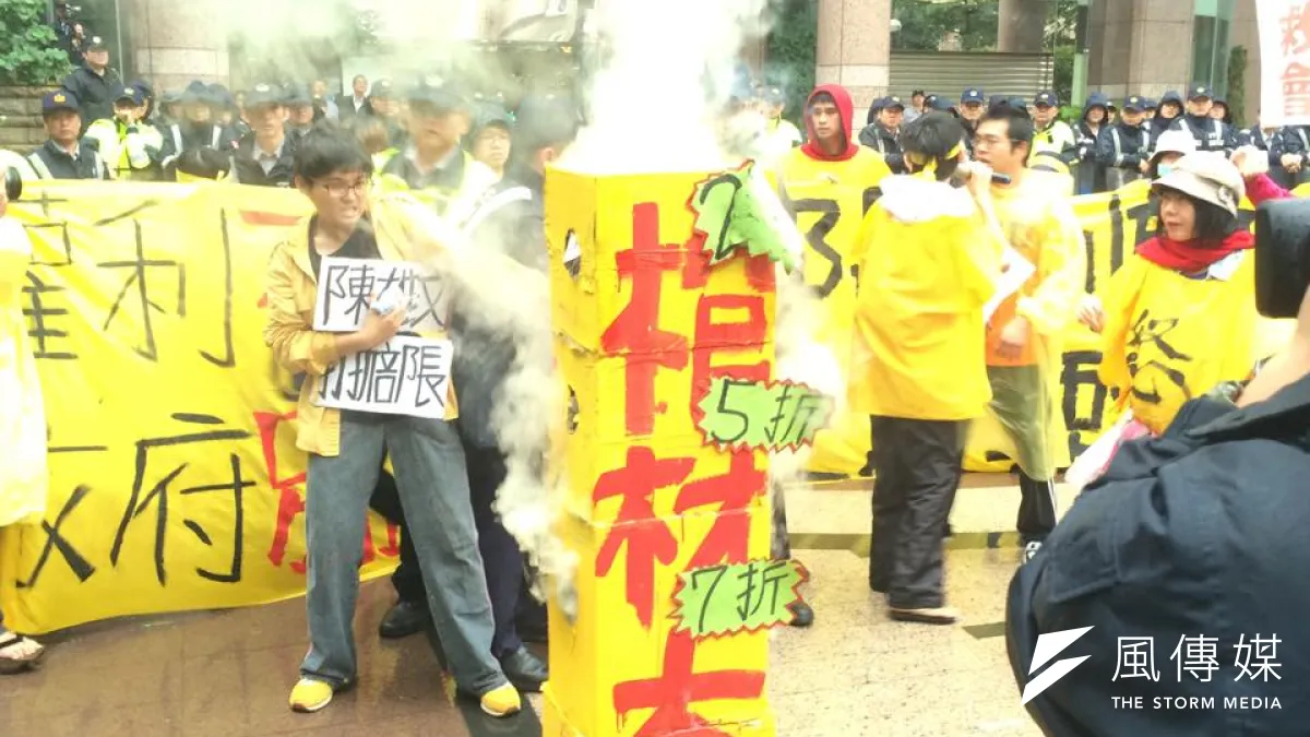 華隆自救會赴勞動部前演出行動劇,燒「官財本」,要求勞動部長陳雄文親自對話。(取自華隆自救會臉書)