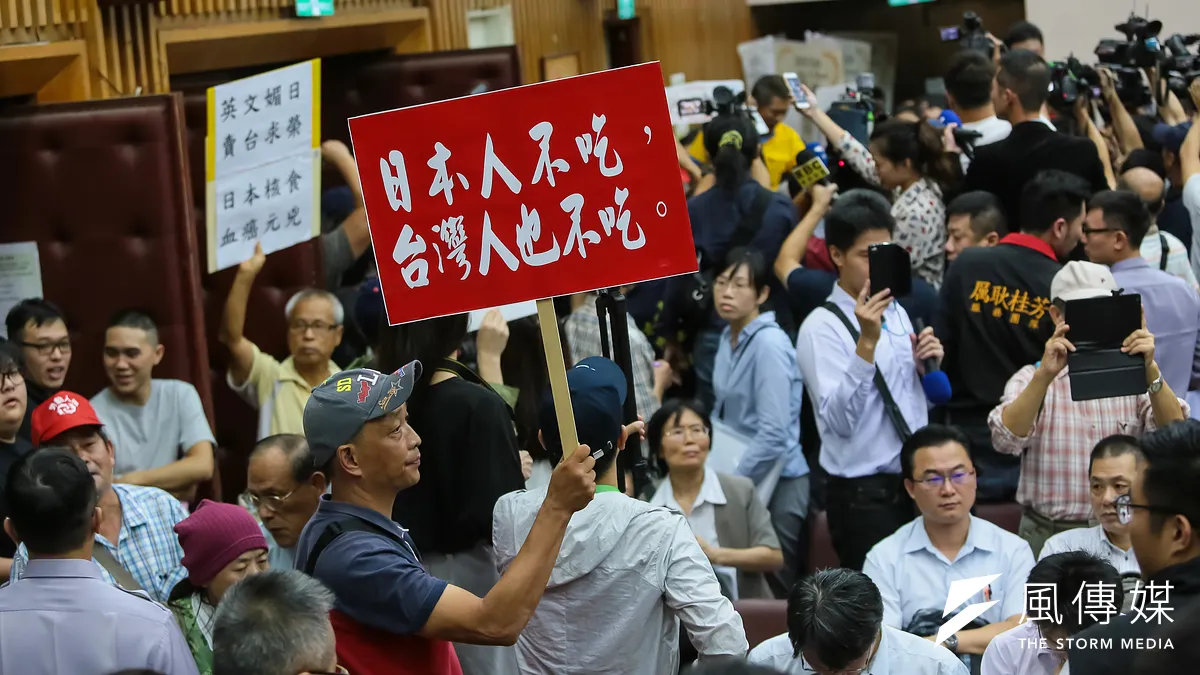 農糧署舉行日本食品輸台公聽會,反對的民眾於開會現場高舉「日本人不吃,台灣人也不吃」的標語。(顏麟宇攝)