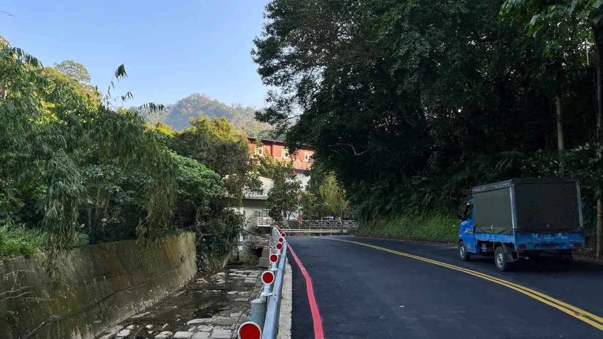 施工後邊坡穩定並拓寬堤頂道路為雙向道增加行車安全。(圖/新北市水利局提供)