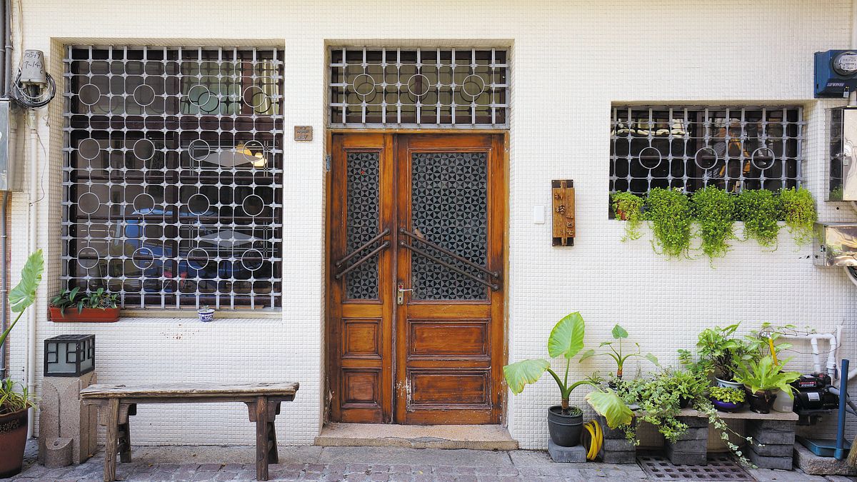 一樓的鐵窗看來像是棋盤上的棋子,裝有舊式銅製門把的門板則去除油漆 露出木門原有色澤。(圖/作者提供) 一樓的鐵窗看來像是棋盤上的棋子,裝有舊式銅製門把的門板則去除油漆 露出木門原有色澤。(圖/作者提供)
