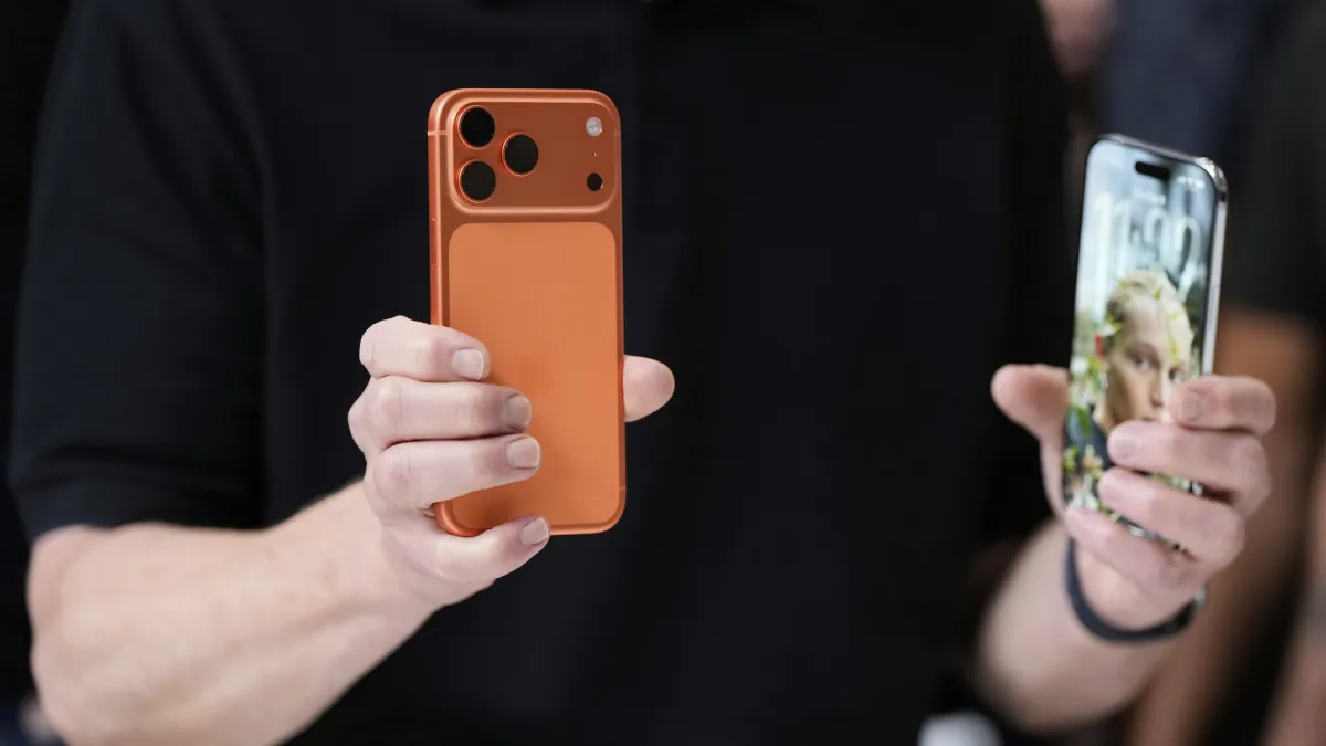 2025年9月9日,蘋果執行長庫克拿著最新的iPhone 17 Pro和iPhone Air。(美聯社)