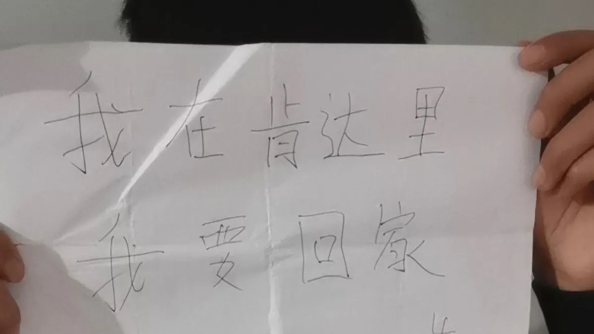 張強舉著一張標語,上面寫著「我在肯達裡(印度尼西亞)我要回家」。(中國勞工觀察)