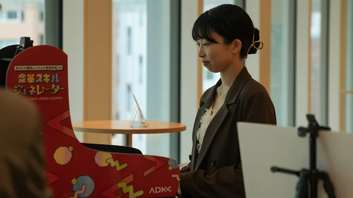 ADKグループが2026年度入社式で、生成AIを用いて個性をトレーディングカード化する体験型筐体を提供し、新入社員に最新技術を通じた「変革者」としての視点を促した。(写真/株式会社ADKホールディングス提供)