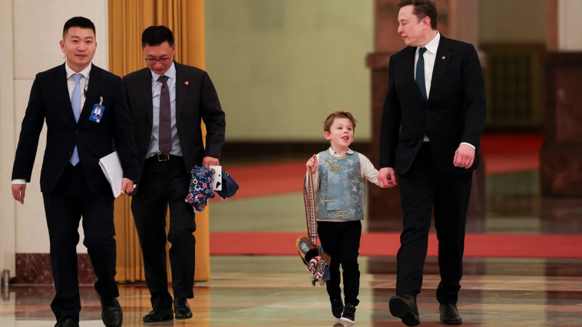 Tesla CEO Elon Musk, right, arrives with his son X Æ A-Xii for the meeting between Chinese Premier Li Qiang and U.S. business representatives, at the Great Hall of the People in Beijing, May 14, 2026. (AP)