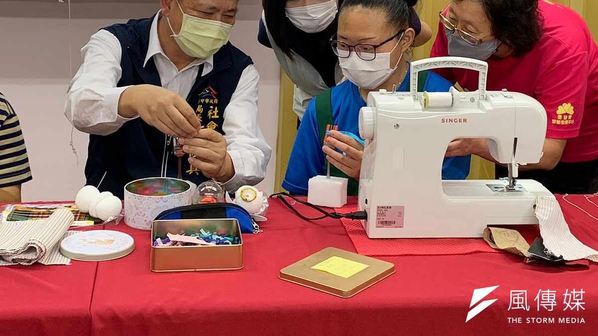 台中市政府社會局長彭懷真跟著試做蝴蝶結,感嘆實在不簡單!(圖/王秀禾攝) 台中市政府社會局長彭懷真跟著試做蝴蝶結,感嘆實在不簡單!(圖/王秀禾攝)