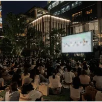麻布台ヒルズの中央広場で9月18日から23日まで、過去最長となる6日間の野外映画イベント「OUTDOOR CINEMA 2026」が開催され、名作6本の日替わり上映や音楽プログラム、多彩なフードトラックが展開される。(写真/麻布台ヒルズPR事務局提供) 麻布台ヒルズの中央広場で9月18日から23日まで、過去最長となる6日間の野外映画イベント「OUTDOOR CINEMA 2026」が開催され、名作6本の日替わり上映や音楽プログラム、多彩なフードトラックが展開される。(写真/麻布台ヒルズPR事務局提供)