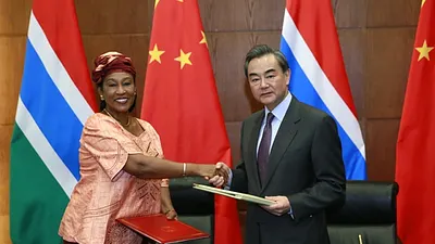 中國外交部長王毅(右)與甘比亞外交部長蓋伊握手,慶祝兩國建交。(取自中國外交部官網)