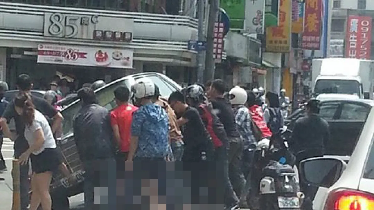 一名騎士被壓在賓士車底,路過的民眾合力抬車將人救出,讓一旁路過的民眾看了紛紛拍照表示溫暖。(取自臉書)