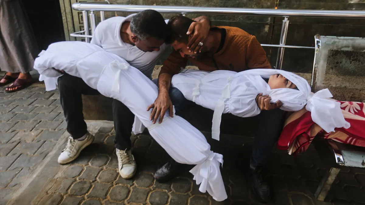 2025年10月29日,加薩市希法醫院一名父親抱著他死於以色列空襲的年幼兒女。(美聯社) 2025年10月29日,加薩市希法醫院一名父親抱著他死於以色列空襲的年幼兒女。(美聯社)