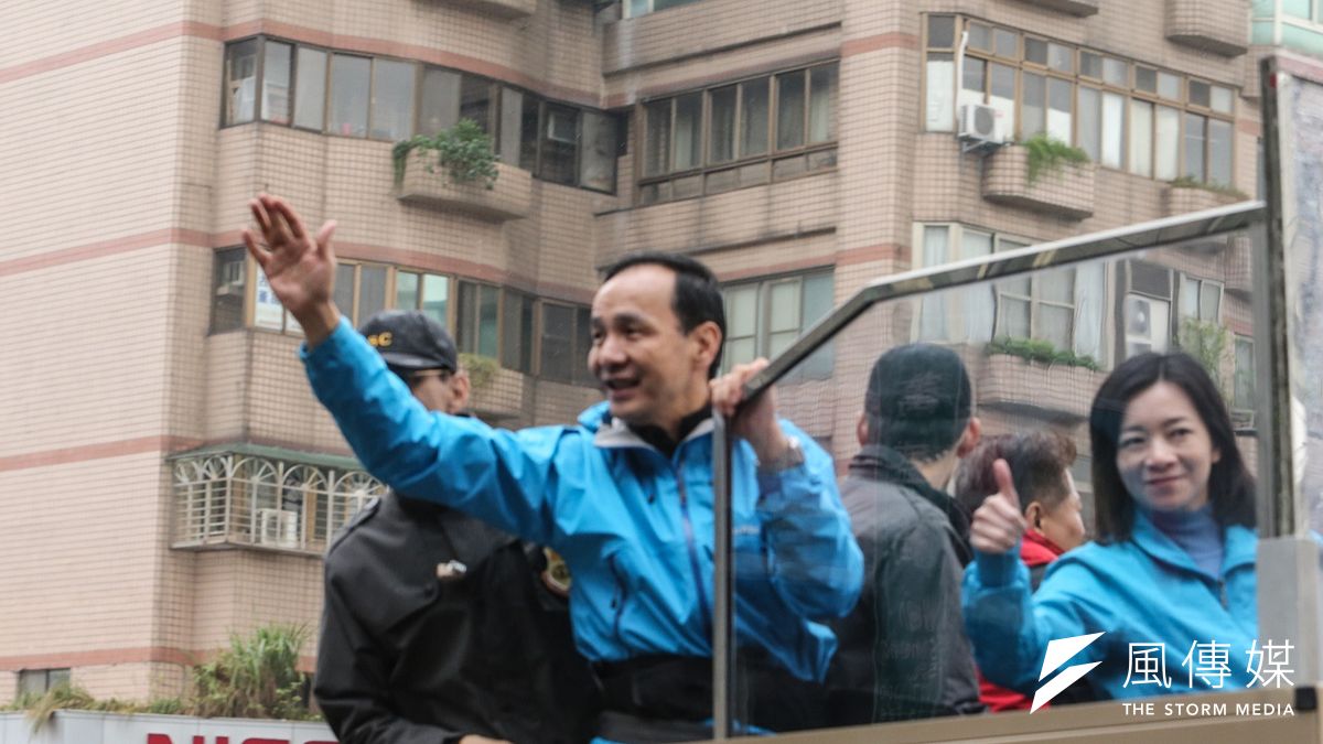 寒風凍雨中,未載雨帽的國民黨總統候選人朱立倫夫婦掃街車隊狂掃台北市街頭。(陳明仁攝) 寒風凍雨中,未載雨帽的國民黨總統候選人朱立倫夫婦掃街車隊狂掃台北市街頭。(陳明仁攝)