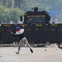 2025年8月31日、インドネシア・ジャカルタの国会議事堂前で、警察に石を投げる抗議者の様子。(AP通信) 2025年8月31日、インドネシア・ジャカルタの国会議事堂前で、警察に石を投げる抗議者の様子。(AP通信)