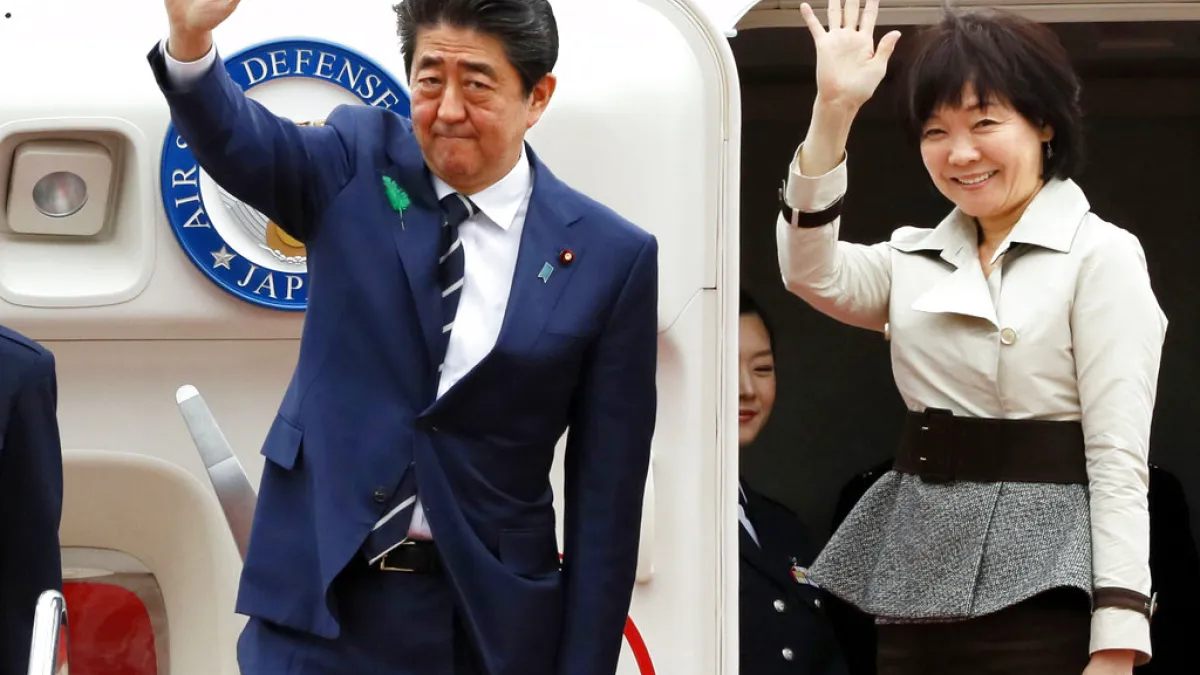 日本首相安倍晉三(左)與夫人安倍昭惠(右)17日登上專機前與媒體揮手,準備訪問美國,會見川普。(AP)