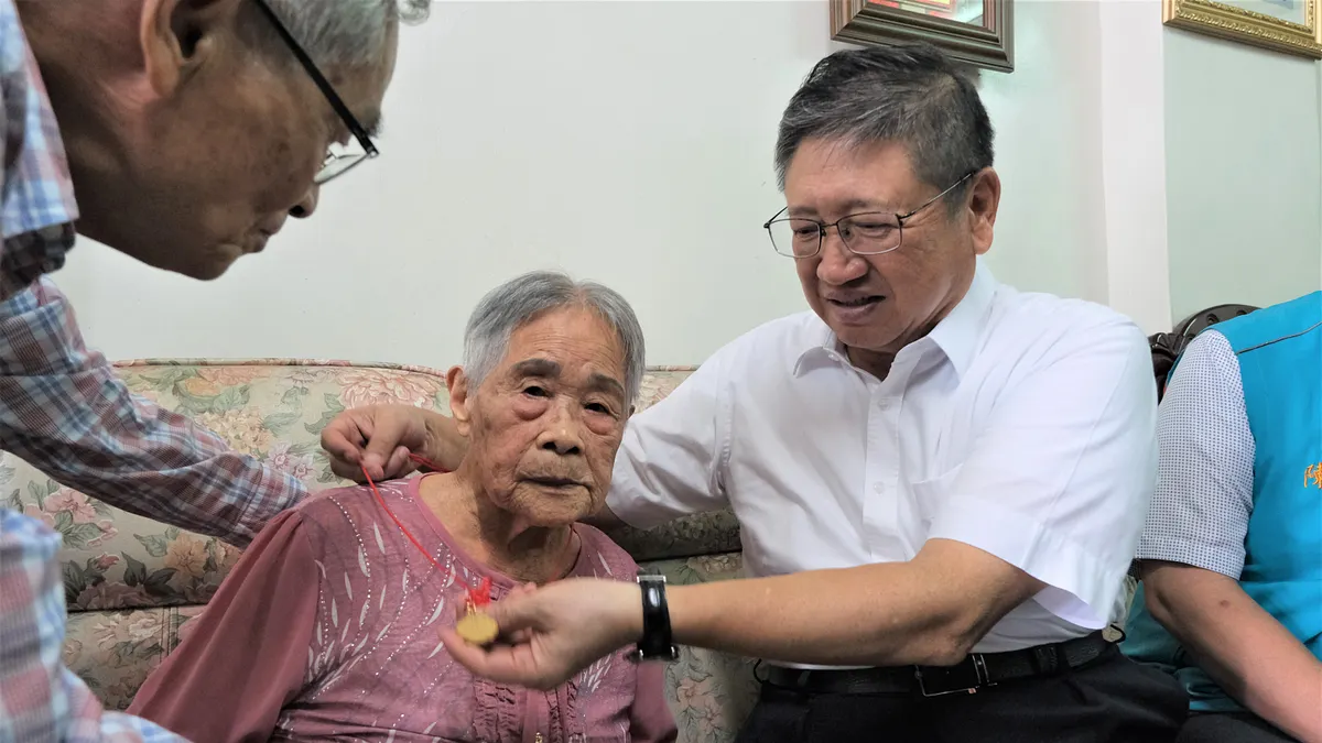 新竹縣長楊文科為106歲人瑞楊蔡甘妹戴上金鎖片。(圖/新竹縣政府提供) 新竹縣長楊文科為106歲人瑞楊蔡甘妹戴上金鎖片。(圖/新竹縣政府提供)