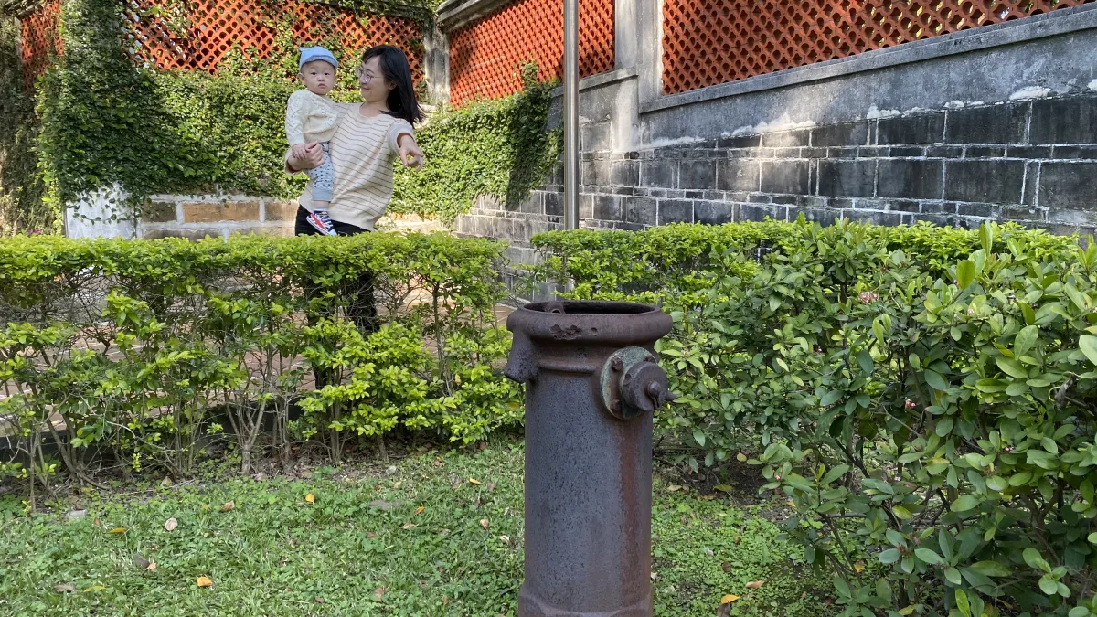 美麗的媽媽與寶貝看著擁有百年歷史的水管頭。(圖/新北市立淡水古蹟博物館提供)